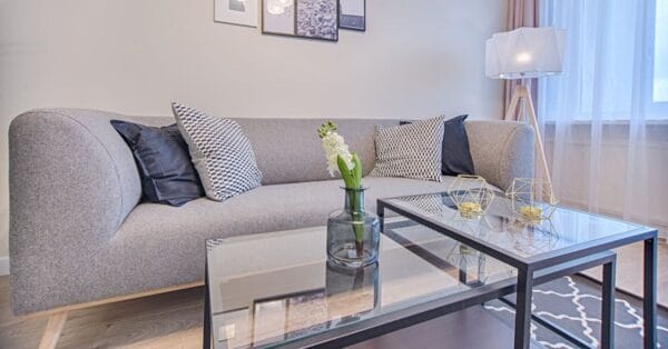 Stue med grå sofa og glasbord